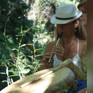 laetitia Djian qui joue de la flûte devant un tambour chamnique